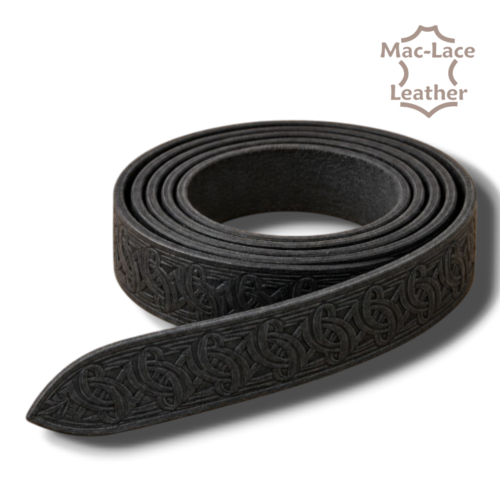 Celtic embossed black vegetable-tanned leather belt blank in 32mm and 38mm widths, displayed with leathercraft tools and an antique-brass buckle.